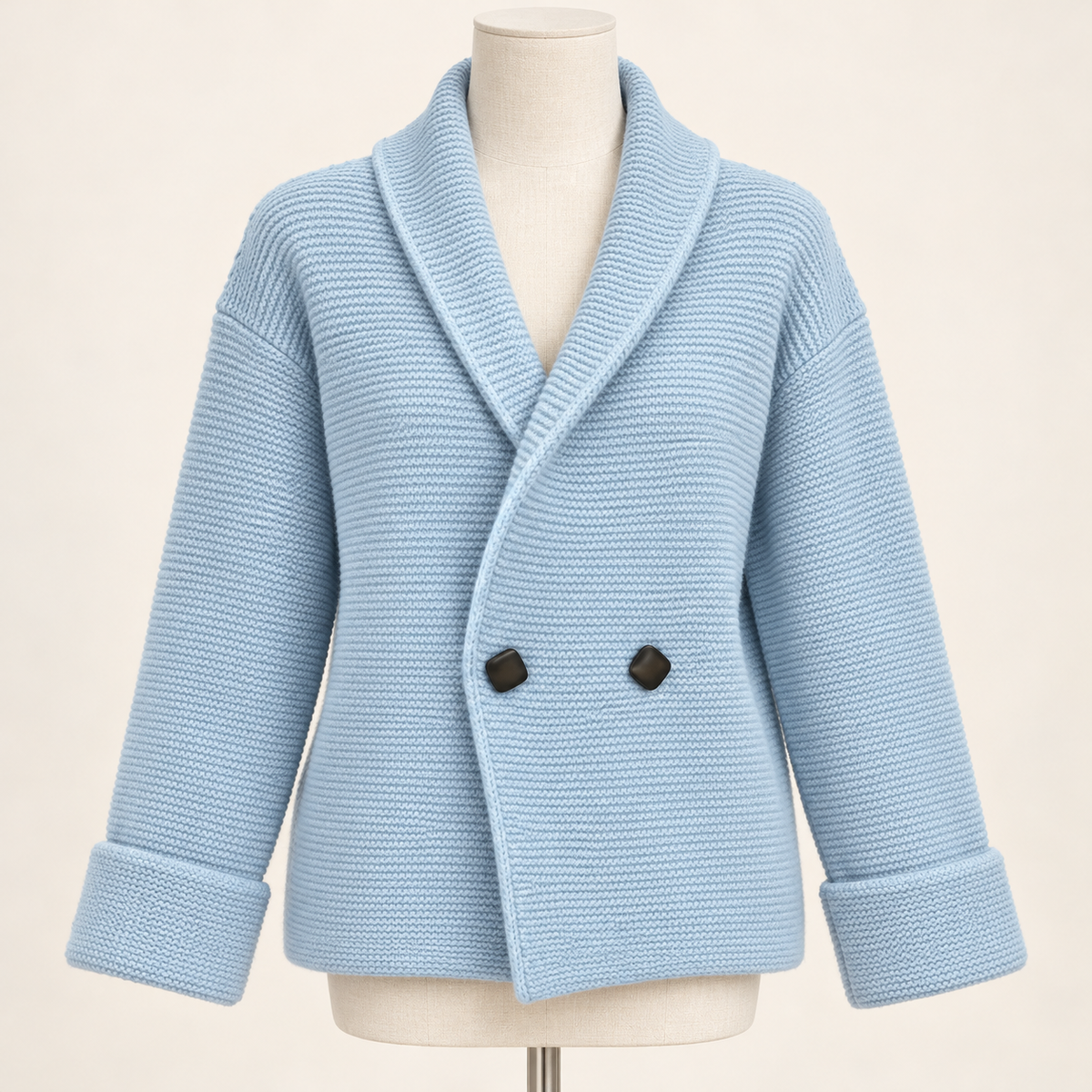 Blue Camille knit cardigan with two dark statement buttons on an ivory studio dress form